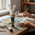 Artist using Acrylic Paint 75ml - Sap Green while painting on canvas at a wooden table with a palette.
