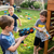 Children playing with the 33CM Electric Light and Sound Submachine Toy Gun in a backyard setting.