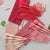 Candy colored makeup brush set displayed with pink pouches and various brushes arranged on a flat surface.