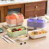 Collapsible Double-Layer Lunch Box set in various colors on a wooden table, ideal for organized and eco-friendly meal transport.