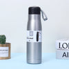 Dual Vacuum Insulated Stainless Steel Water Bottle on a blue background with a plant and books nearby.
