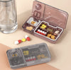 Portable Pill Organiser with compartments for sorting daily medications and vitamins, placed next to a glass of water.