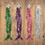 Festive Tinsel Garland 11cm x 2m shown in green, purple, red, and silver colors on a wooden background.