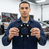 Man holding Forged Hubcentric Wheel Spacers in a workshop, showcasing its design for improved vehicle stability.