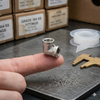 304 Stainless Steel 90 Degree Elbow Pipe Fitting held on a finger, showcasing its precision and quality.
