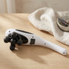 5-Head Handheld Massager resting on a tabletop with a soft fabric and decorative bowl in the background.