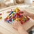 Child building with the Colourful Sticks & Balls Construction Set, creating a colorful pyramid structure.