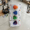 3D Printed Articulated Spider Toy Ornament alongside vibrant 3D printed designs in a creative workspace.