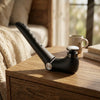 Folding Handheld Body Massager on a wooden table with a cozy background.
