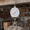 Precision Dial Hanging Scale measuring weight of a bag in a workshop setting.