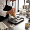 Baking with Non-Stick 6-Cup Shell-Shaped Muffin Pan, chef filling molds with batter.