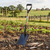 Farming Digging Square-Mouth Shovel standing in a garden with vegetables and gardening tools in the foreground.