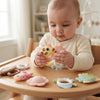 A baby playing with the Baby Sensory Rattle & Teether Toy Set, exploring colorful shapes and textures.