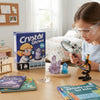 A child observing crystals with a magnifying glass next to the Crystal Quest Kids Growing Kit.