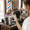 Barber using 12 Piece Professional Barber Hair Sectioning Clips on a client's hair for precision styling.