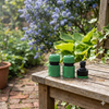 Adjustable High Pressure Garden Water Gun attachments displayed on a wooden bench with a garden background.