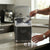 Portable Countertop Ice Maker in use, person scooping ice cubes from machine on kitchen countertop.
