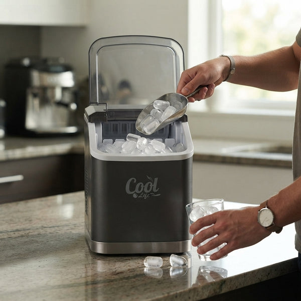 Portable Countertop Ice Maker in use, person scooping ice cubes from machine on kitchen countertop.