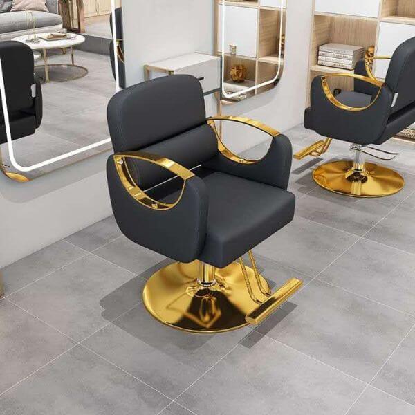Gold Accent Hairdresser Salon Chair with luxurious black upholstery and gold accents in a modern salon interior.