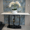 Golden & White Marble Console Table with flowers against a stylish marble wall.