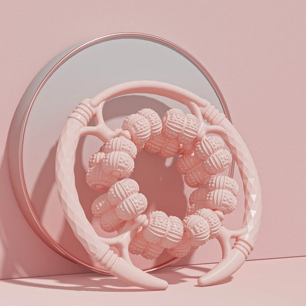 32 Wheel Ring Muscle Relaxation Leg Massager on a pink surface with a mirror backdrop.
