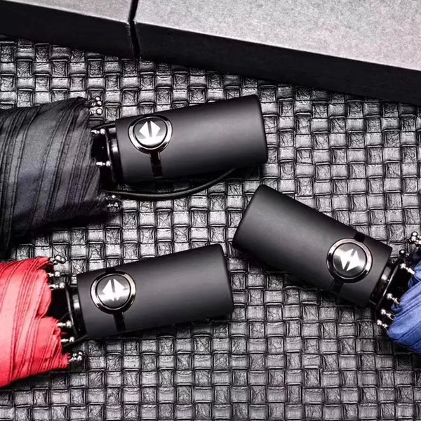 3-Fold Minimalist Automatic Umbrella in red, blue, and black on a textured surface with buttons.