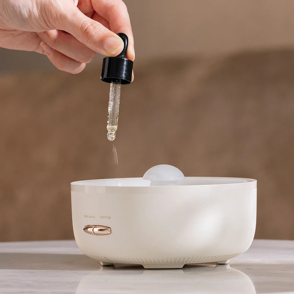 Person adding essential oil to the 400ml Ultrasonic Essential Oil Diffuser with Remote Control.