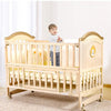 Multi-functional Wood Baby Crib Kids Cot with smiling toddler standing inside, providing safe sleeping space.