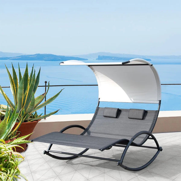 Garden Balcony Leisure Metal Garden Chair on a sunny terrace overlooking the sea with a sunshade and potted plants.