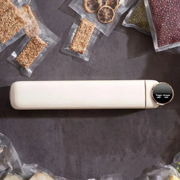 Portable Mini Food Vacuum Packing Organising Sealer on a countertop surrounded by vacuum-sealed snacks and fruits.