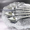 5-Piece Silverware Set displayed on a decorative glass plate, featuring stainless steel flatware for dining.