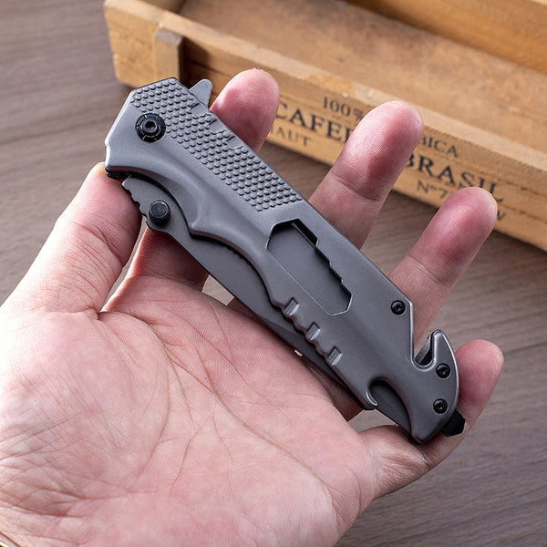 Iron Grip Full Metal Survival Folding Knife held in hand with practical design and rugged features.