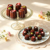 Carbon Steel 6-Cup Cannelé Baking Tray with beautifully decorated cannelés on elegant plates.