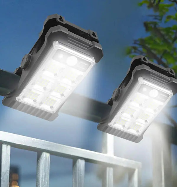 Portable Solar Clip Lights Motion Sensor providing bright illumination on garden fence at night.