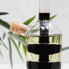 2 in 1 Olive Oil Vinegar Bottle Dispenser showing cork stopper and liquid layers, perfect for functional decor in homes.