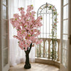 Artificial Silk Cherry Blossom Tree beautifully displayed indoors near an ornate window and floral accents.