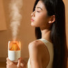 Woman using the Volcano USB Humidifier & Aroma Diffuser, enjoying soothing mist in a tranquil setting.