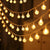 Bubble Ball Fairy String Lights displayed in warm glow, creating a magical ambiance perfect for gardens and wedding venues.