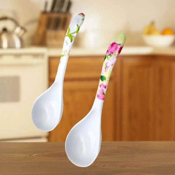 Two Ceramic Flower Handle Soup Spoons on a kitchen table, showcasing floral designs and smooth white bowls.