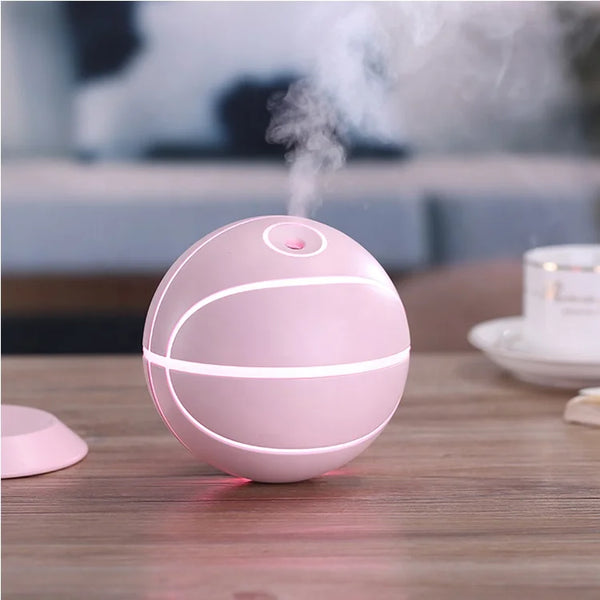 Basketball Mini USB Humidifier Lamp on a wooden table, emitting a gentle mist and soft ambient light.