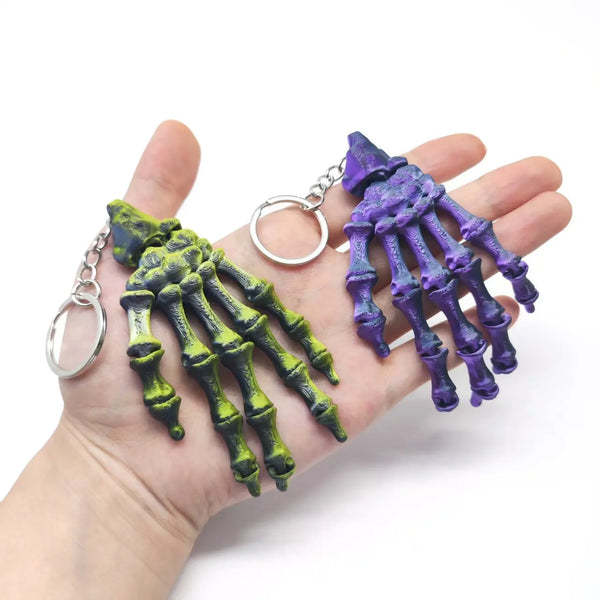 3D Printed Skull Hand Keychain Pendant displayed in a hand, featuring vibrant colors and detailed bone design.