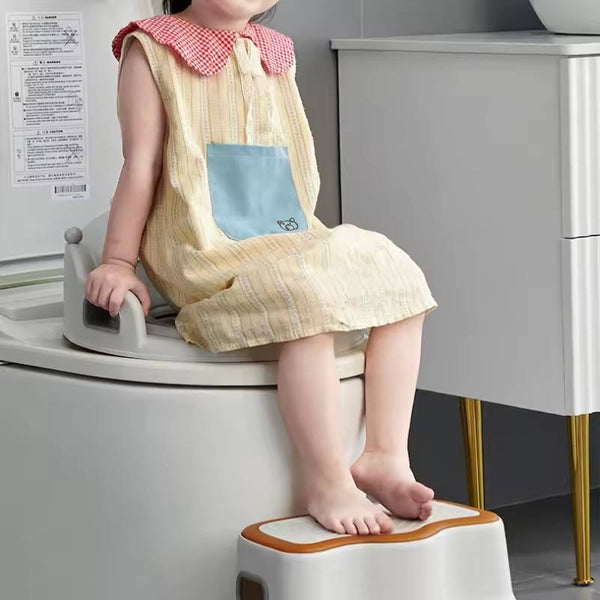 Child using Baby and Child Toilet Seat Ring on a toilet for potty training, wearing a cute dress.