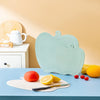 Apple Shape Plastic Cutting Board displayed on a kitchen countertop with fruits and knife.