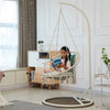 Girl enjoying a book on a portable heavy duty outdoor rope hammock in a stylish indoor setting.