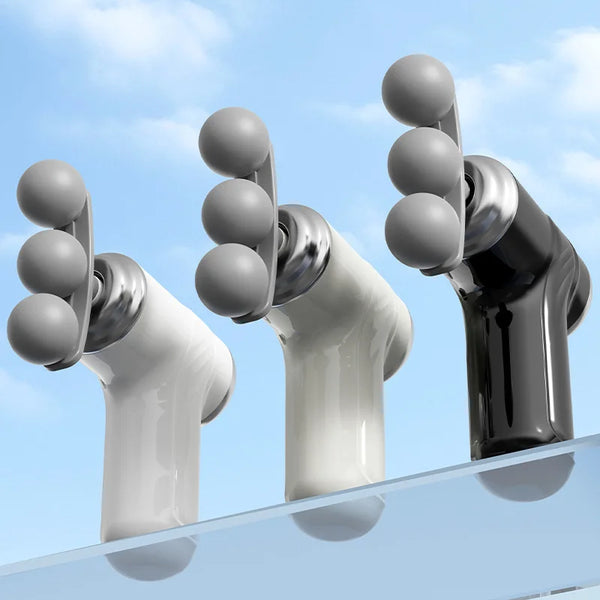 Three interchangeable heads of the 3-Head Body Massager in black, white, and gray against a blue sky.