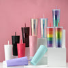 Assorted Matte Black Studded Bling Cup Tumblers in various colors displayed on pedestals with a pink background.