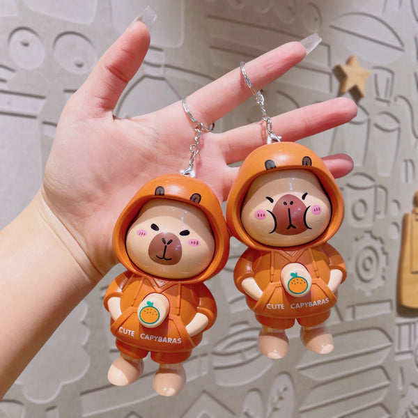 Super Cute Rotatable Head Capybara Keychain held in a hand, showcasing its adorable design and outfit.