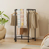 Rotating Clothes Rack with Wheels displaying clothing and accessories in a stylish home setting.