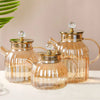 Elegant Large Capacity All-Glass Tea Set featuring three glass teapots with gold accents on a stylish table.