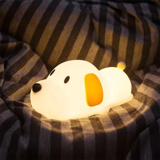 The Lumipets Puppy Night Light resting on a cozy blanket, providing a soft glow for bedtime comfort.